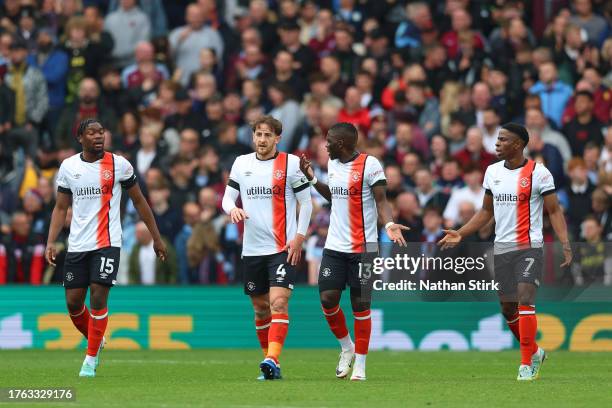 Teden Mengi, Tom Lockyer, Marvelous Nakamba and Chiedozie Ogbene of Luton Town react after John McGinn of Aston Villa scores the team's first goal...