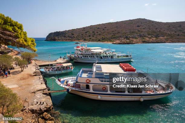 large boats full of tourists exploring the clear waters and hot, dry coastline in kolokitha, near elounda, crete - tropisch klimaat 個照片及圖片檔