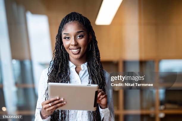 emotional intelligence (ei) is a key leadership skills for digital workplace. portrait of an african-american businesswoman using a tablet computer in a financial business office. - ei stock pictures, royalty-free photos & images