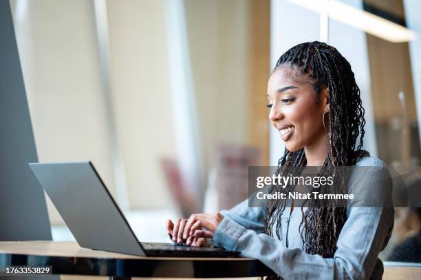 business communication can build and encourage innovation positive company culture. side view of a female african-american ceo on a web conference meeting with a partner via a laptop computer during business travel at a hotel lounge. - emotional intelligence stock pictures, royalty-free photos & images