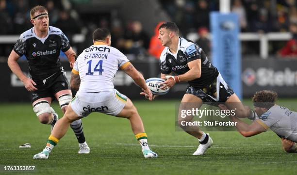 Falcons wing Adam Radwan passes despite in the grasps of Angus Scott-Young of Saints during the Gallagher Premiership Rugby match between Newcastle...