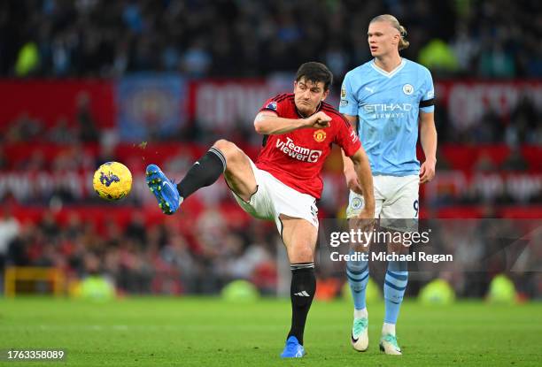 Harry Maguire of Manchester United passes the ball whilst under pressure from Erling Haaland of Manchester City during the Premier League match...