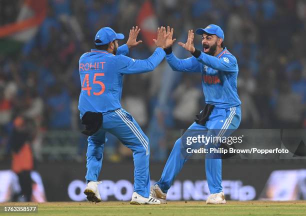 Virat Kohli and Rohit Sharma of India celebrate after the dismissal of Moeen Ali during the ICC Men's Cricket World Cup India 2023 between India and...