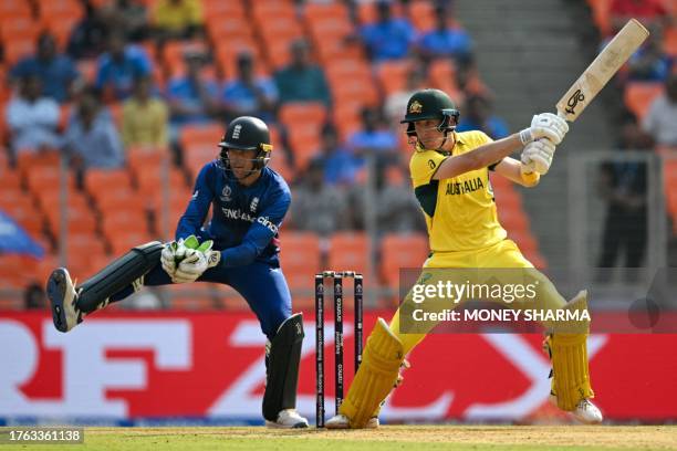 Australia's Marnus Labuschagne plays a shot as England's wicketkeeper captain Jos Buttler watches during the 2023 ICC Men's Cricket World Cup one-day...