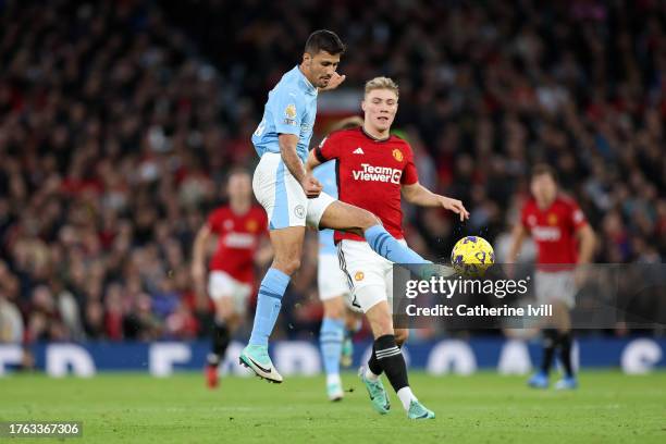 Rodri of Manchester City passes the ball whilst under pressure from Rasmus Hojlund of Manchester United during the Premier League match between...