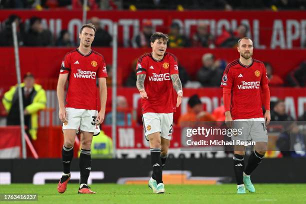 Jonny Evans, Victor Lindeloef and Christian Eriksen of Manchester United look dejected after Erling Haaland of Manchester City scores his team's...