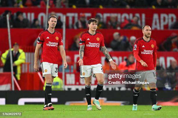 Jonny Evans, Victor Lindeloef and Christian Eriksen of Manchester United look dejected after Erling Haaland of Manchester City scores his team's...