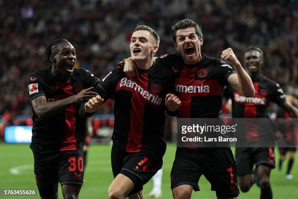 Florian Wirtz of Bayer Leverkusen celebrates with Jonas Hofmann and Jeremie Frimpong after scoring the team's first during the Bundesliga match...