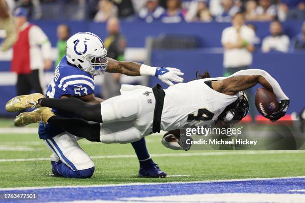 Alvin Kamara of the New Orleans Saints dives past Shaquille Leonard of the Indianapolis Colts while scoring a receiving touchdown during the first...