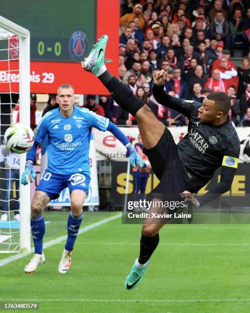 Kylian Mbappe of Paris Saint-Germain play the ball over Marco Bizot of Brest during the Ligue 1 Uber Eats match between Stade Brestois 29 and Paris...