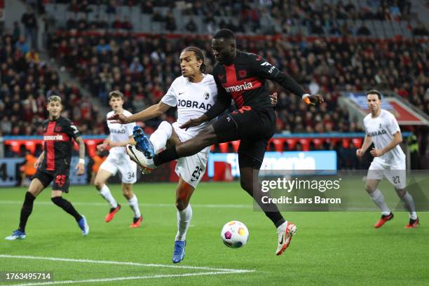 Victor Boniface of Bayer Leverkusen battles for possession with Kiliann Sildillia of Sport-Club Freiburg during the Bundesliga match between Bayer 04...