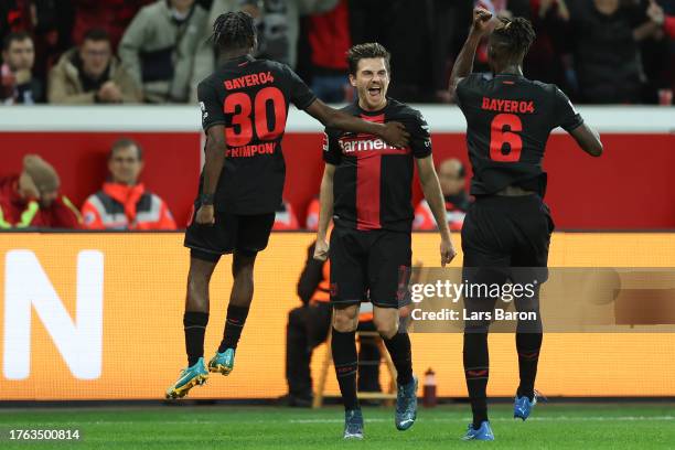 Jonas Hofmann of Bayer Leverkusen celebrates after scoring the team's second goal with Odilon Kossounou and Jeremie Frimpong during the Bundesliga...