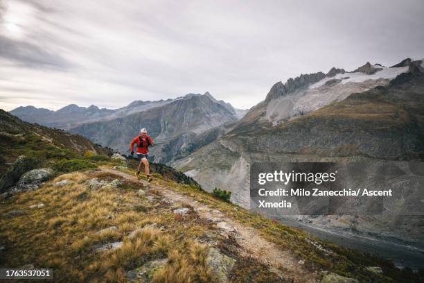 senior man runs along mountain ridge - rock mountain stock pictures, royalty-free photos & images