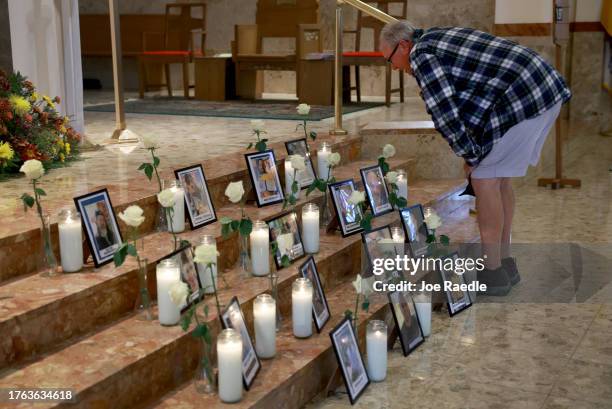 Tim Conrad looks on at a picture of his son, Thomas “Tommy” Conrad, during a memorial at the Holy Family Church for those whom a mass shooter killed...