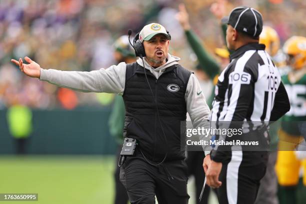 Head coach Matt LaFleur of the Green Bay Packers talks with down judge Patrick Holt during the second half at Lambeau Field on October 29, 2023 in...