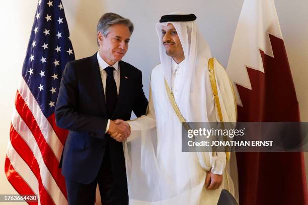 Secretary of State Antony Blinken shakes hands with Qatar's Prime Minister and Foreign Minister Mohammed bin Abdulrahman al-Thani during a day of...