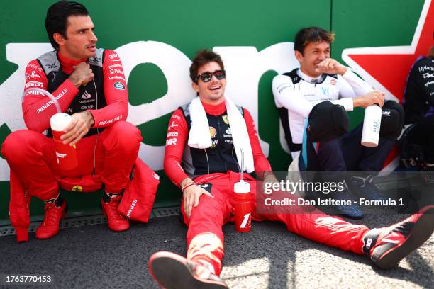 Carlos Sainz of Spain and Ferrari, Charles Leclerc of Monaco and Ferrari and Alexander Albon of Thailand and Williams look on as they wait on the...