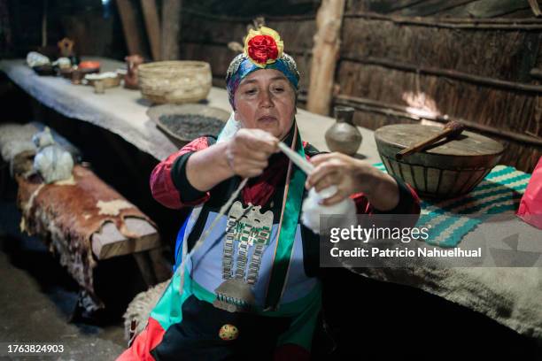 elderly mapuche woman spinning sheep wool in the interior of her ruca - stammeskunst stock-fotos und bilder