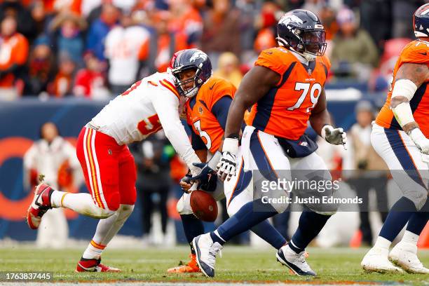 George Karlaftis of the Kansas City Chiefs forces a fumble from Russell Wilson of the Denver Broncos during the second quarter at Empower Field At...