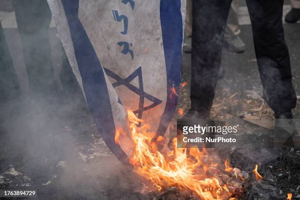 An Iranian protester burns an Israeli flag during a rally marking the anniversary of the U.S. Embassy occupation in Tehran, November 4, 2023.