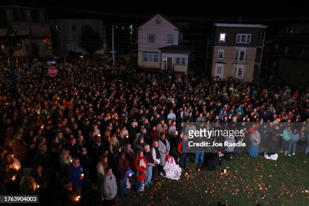 An overflow crowd watches a television screen as it broadcasts from inside the Basilica of Saints Peter and Paul the remembrance ceremony on October...