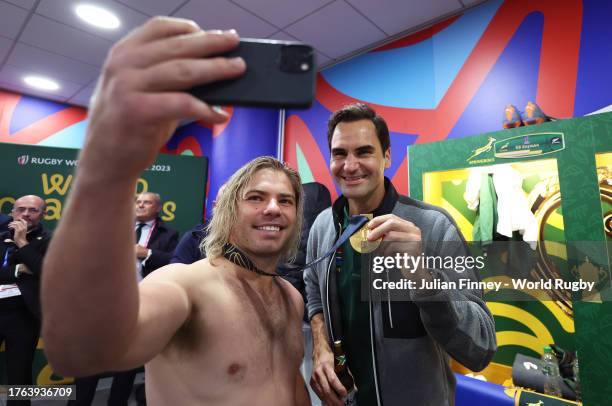 Faf de Klerk of South Africa celebrates victory inside the dressing room with Tennis Legend Roger Federer following the Rugby World Cup Final match...