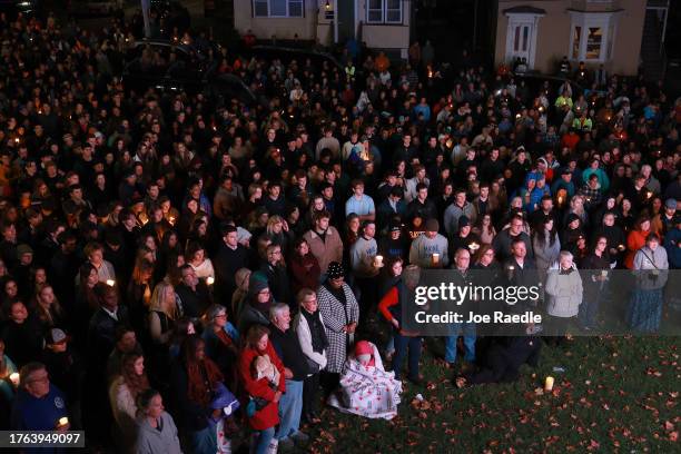 Crowd of people watch a television screen as it broadcasts from inside the Basilica of Saints Peter and Paul the remembrance ceremony on October 29,...