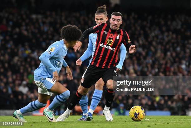 Manchester City's English defender Rico Lewis and Manchester City's English midfielder Kalvin Phillips vie with Bournemouth's English midfielder Joe...