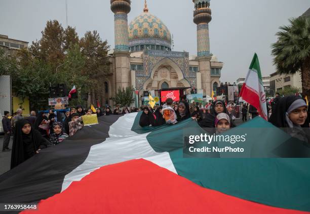 Veiled Iranian schoolgirls carrying a massive Palestinian flag while taking part in an anti-U.S. And anti-Israel rally marking the anniversary of the...