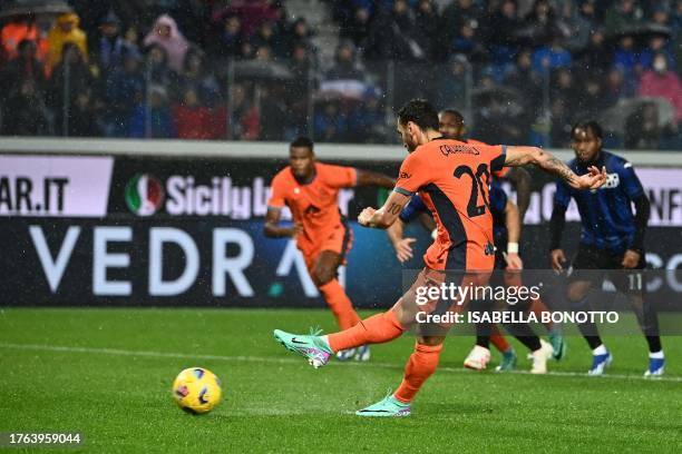 Inter Milan's Turkish midfielder Hakan Calhanoglu kicks and scores a penalty during the Italian Serie A football match between Atalanta and Inter...