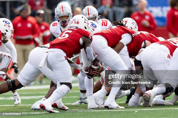 Gavin Wimsatt of the Rutgers Scarlet Knights takes the snap and hands the ball to Kyle Monangai of the Rutgers Scarlet Knights on 4th down to get a...