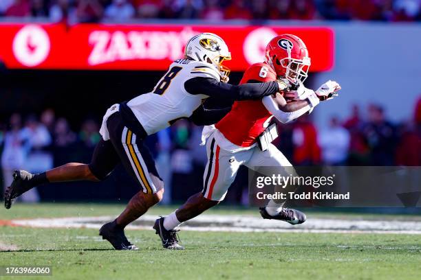 Dominic Lovett of the Georgia Bulldogs is tackled by Joseph Charleston of the Missouri Tigers after the reception during the first half at Sanford...