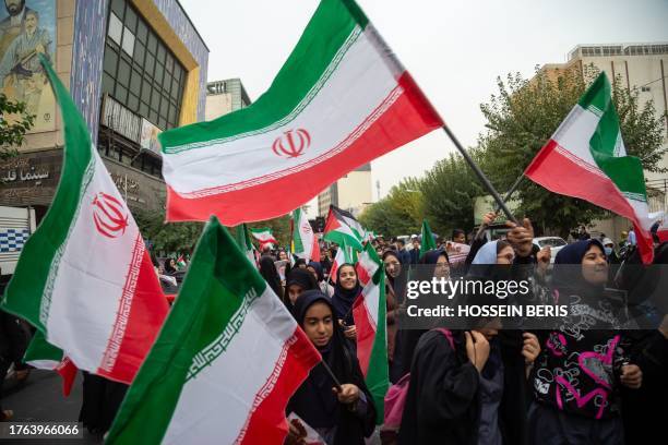 Tehran, Iran. Iranian school girls wave Iranian and Palestinian flags during a rally in front of the former U.S. Embassy in Tehran, Iran, marking...