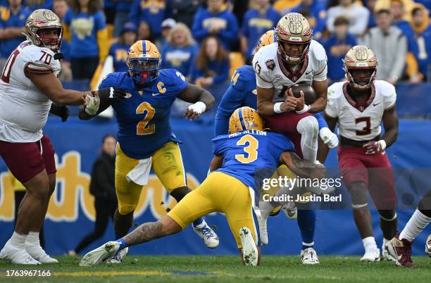 Jordan Travis of the Florida State Seminoles attempts to jump over a tackle attempt by Donovan McMillon of the Pittsburgh Panthers in the first...