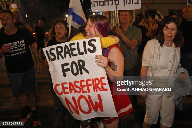 Israeli left-wing activists hold placards and chant slogans during a demonstration calling for a ceasefire between Israel and Hamas, in Tel Aviv on...