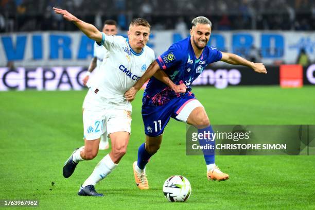 Marseille's French midfielder Valentin Rongier and Lille's Algerian midfielder Adam Ounas fight for the ball during the French L1 football match...