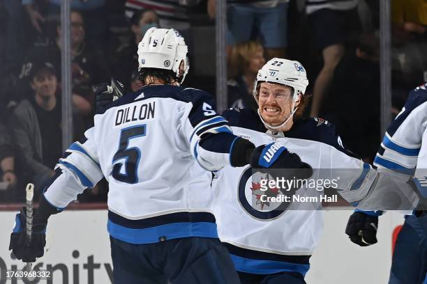 Brenden Dillon of the Winnipeg Jets celebrates with teammate Mason Appleton after scoring a goal against the Arizona Coyotes during the third period...