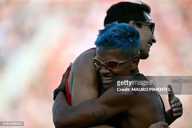 Venezuela's Jose Antinio Maita Perez , gold medal, hugs Mexico's Jesus Tonatiu Lopez Alvarez , silver medal, after the men's 800m final of the Pan...