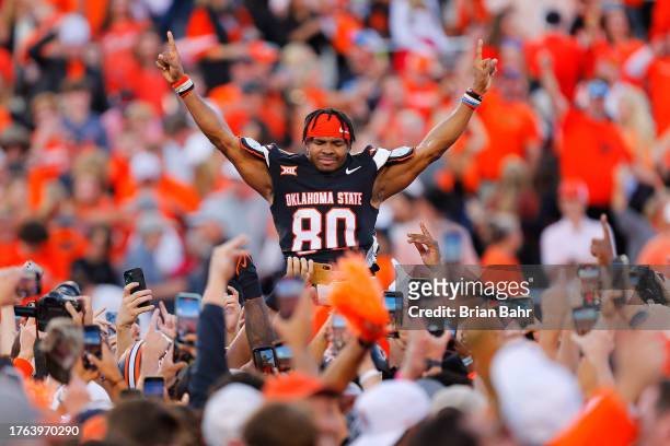 Wide receiver Brennan Presley of the Oklahoma State Cowboys savors a 27-24 win over the Oklahoma Sooners in the arms of the crowd after the last...