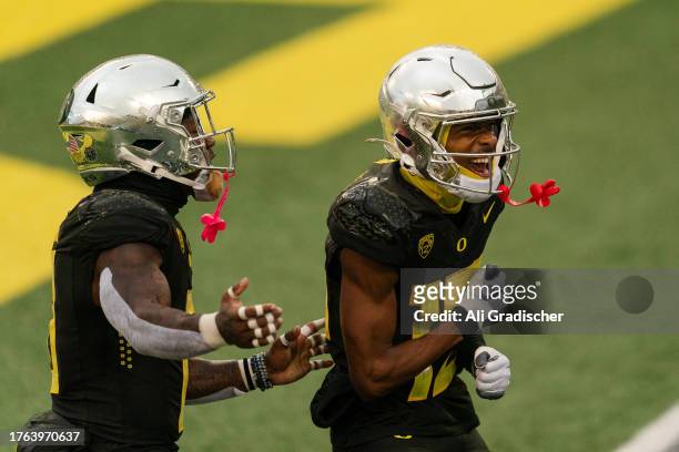 Tez Johnson of the Oregon Ducks celebrates with teammate Bucky Irving after Johnson's touchdown during the first half of the game against the...
