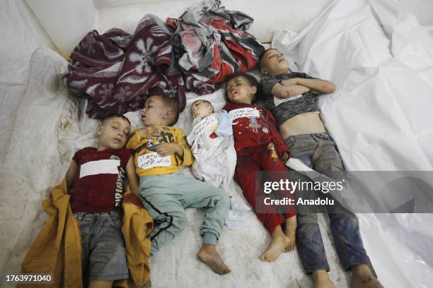 Dead bodies of a baby and children are seen as Palestinians including children injured, died in Israeli attacks on Al-Maghazi refugee camp brought to...