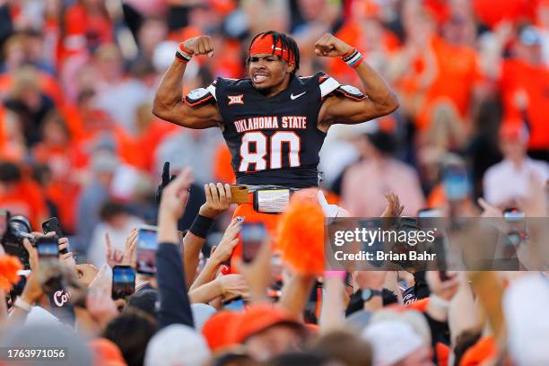 Wide receiver Brennan Presley of the Oklahoma State Cowboys celebrates a 27-24 win over the Oklahoma Sooners in the arms of the crowd after the last...