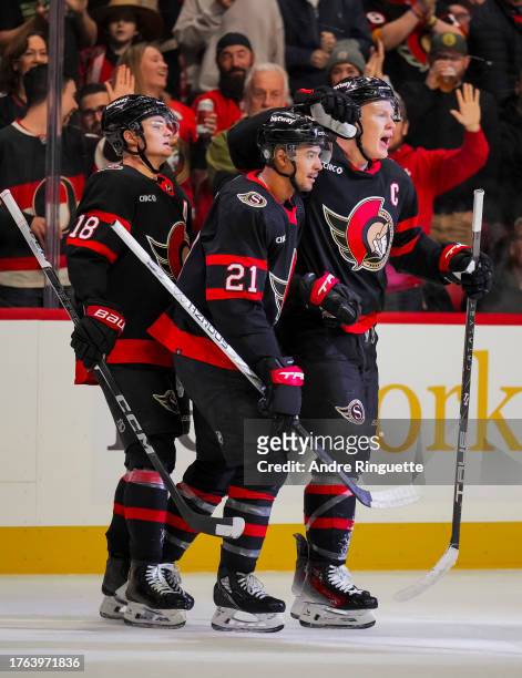 Brady Tkachuk of the Ottawa Senators celebrates his first period goal against the Tampa Bay Lightning with teammates Mathieu Joseph and Tim Stützle...