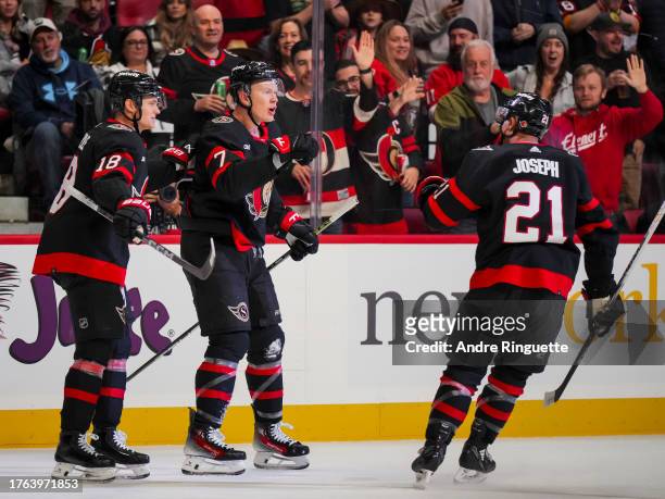 Brady Tkachuk of the Ottawa Senators celebrates his first period goal against the Tampa Bay Lightning with teammates Tim Stützle and Mathieu Joseph...