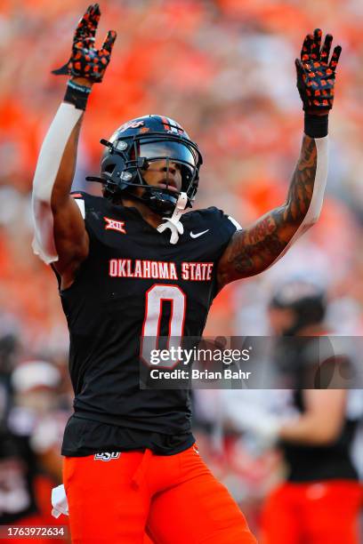 Running back Ollie Gordon II of the Oklahoma State Cowboys celebrates by doing the OSU wave after scoring a touchdown against the Oklahoma Sooners in...