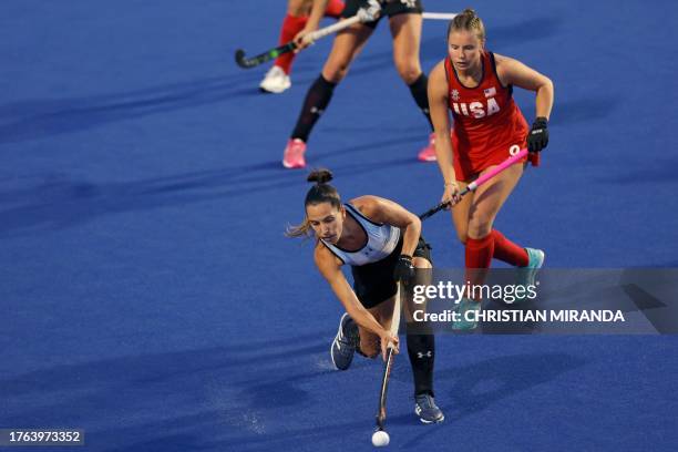 Argentina's Eugenia Trinchinetti controls the ball over US' Madeleine Zimmer during the field hockey women's team gold medal match between Argentina...