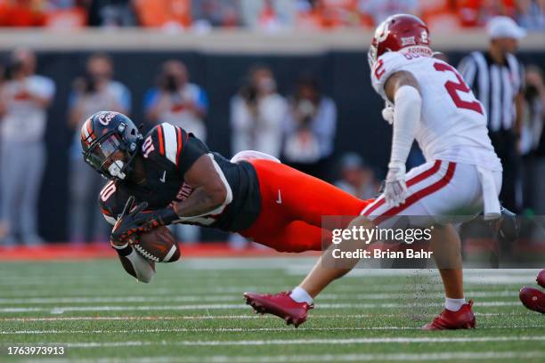 Wide receiver Rashod Owens of the Oklahoma State Cowboys makes a 30-yard catch against defensive back Billy Bowman Jr. #2 of the Oklahoma Sooners in...