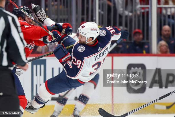 Tom Wilson of the Washington Capitals finishes a check on Boone Jenner of the Columbus Blue Jackets during a game at Capital One Arena on November 4,...