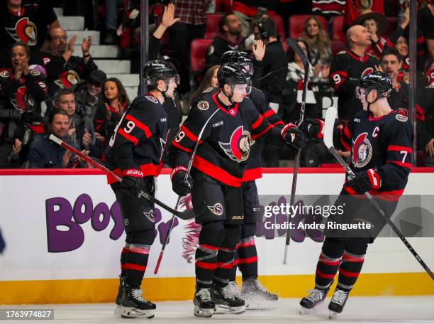 Drake Batherson of the Ottawa Senators celebrates his third period goal against the Tampa Bay Lightning with teammates, Josh Norris, Tyler Kleven and...