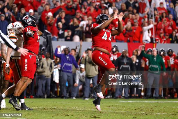 Brandon Cleveland of the NC State Wolfpack shows "The U" sign following a defensive play during the second half of the game against the Miami...